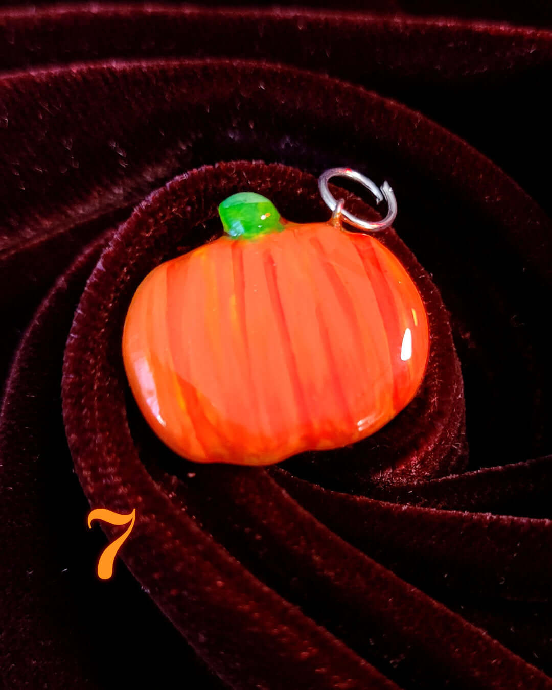 Charm ou pendentif fait main en forme de citrouille orange.