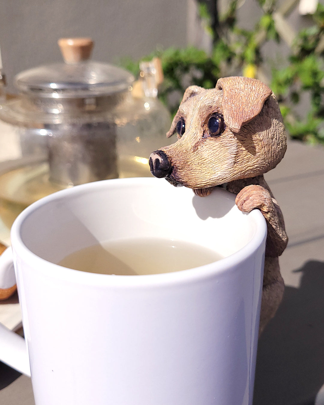 Mini figurine en forme de labrador accrochée à une tasse de thé vert