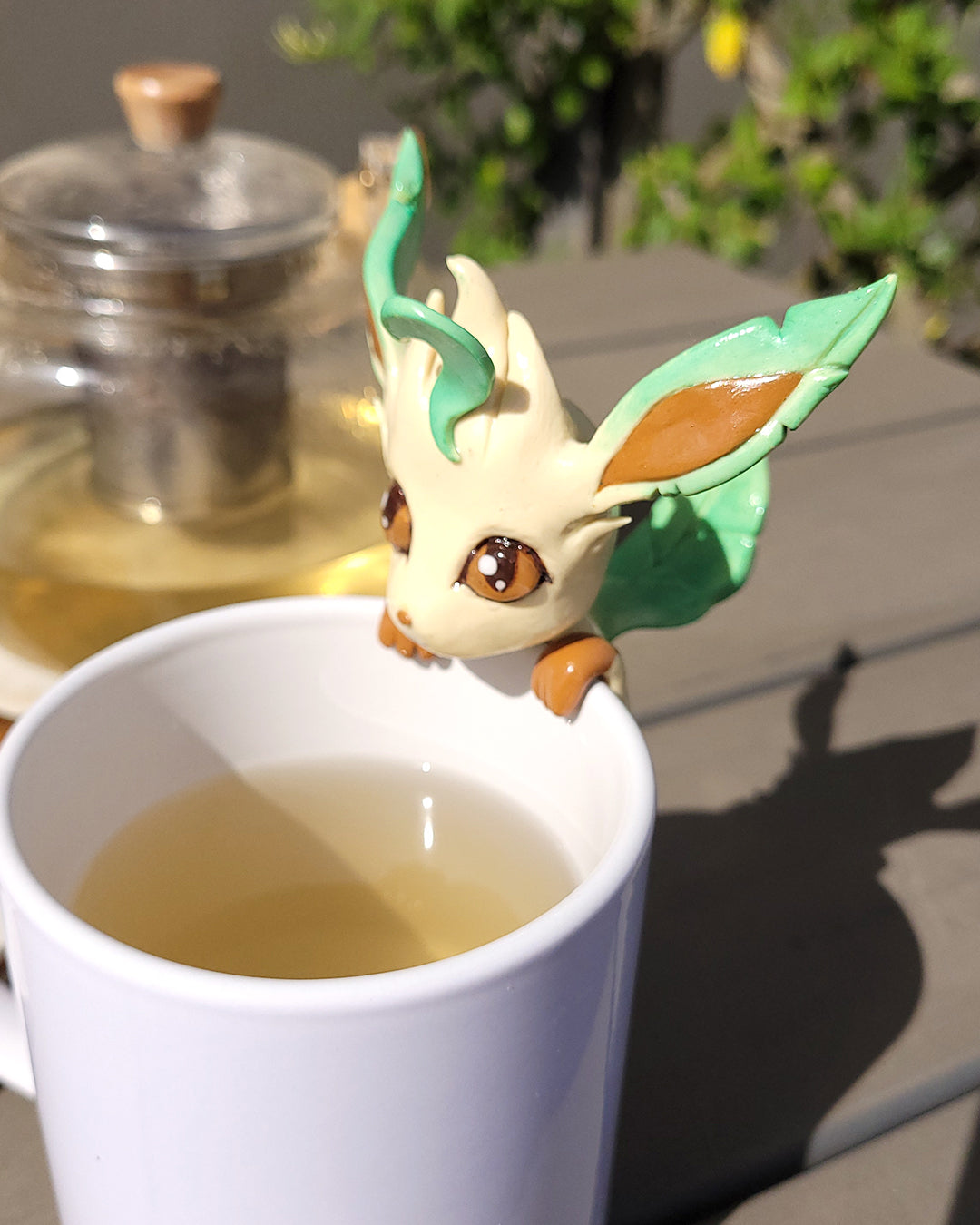 Mini figurine en forme de Phyllali accrochée à une tasse de thé vert