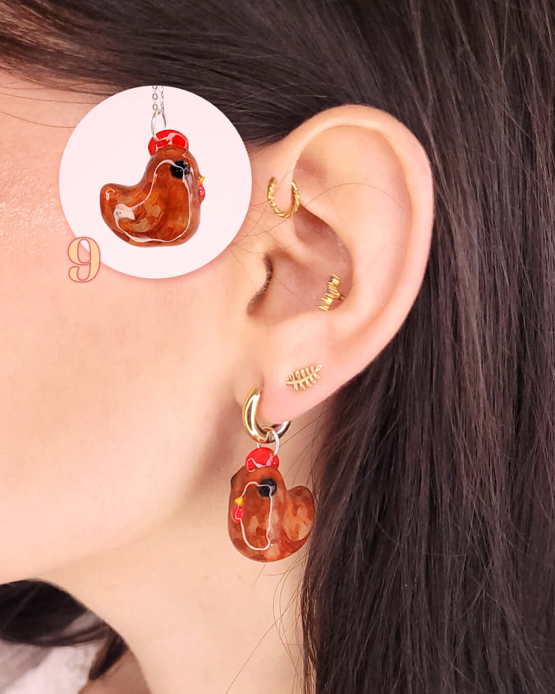 Oreille portant un charm sur un anneau en forme de poule rousse
