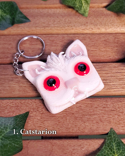 Porte-clef en forme de tête de chat vampire blanc aux yeux rouges inspiré de Astarion de Baldur's Gate 3