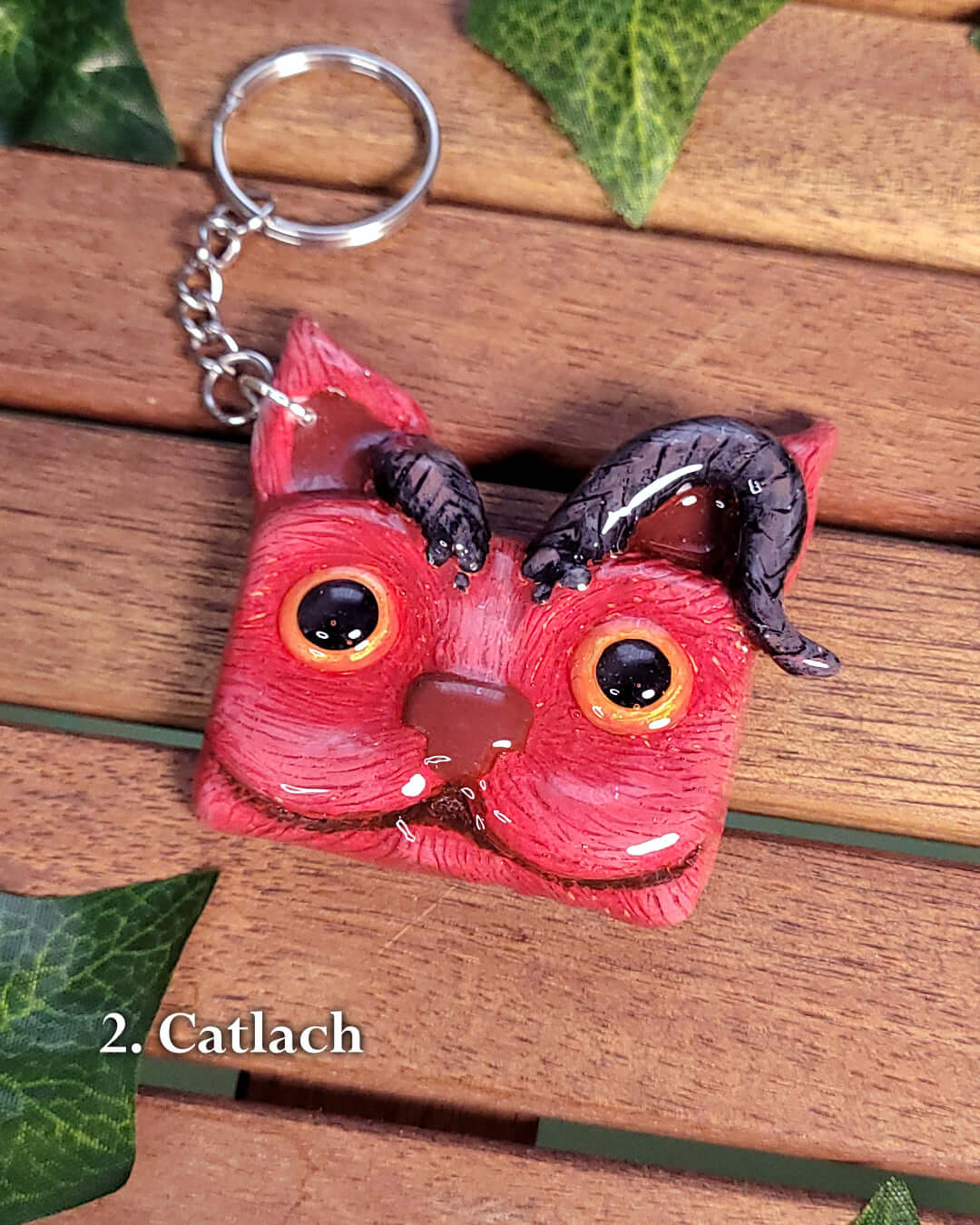 Porte-clef en forme de tête de chat rouge avec des cornes inspiré de Karlach de Baldur's Gate 3