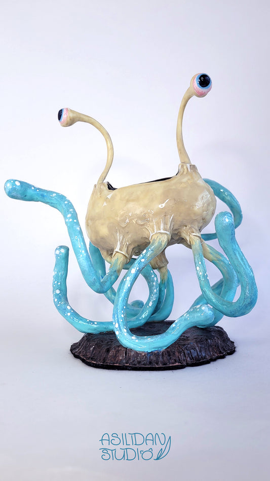 Figurine d'un Flumph de Donjons et Dragons, sorte de gros poulpe beige et turquoise