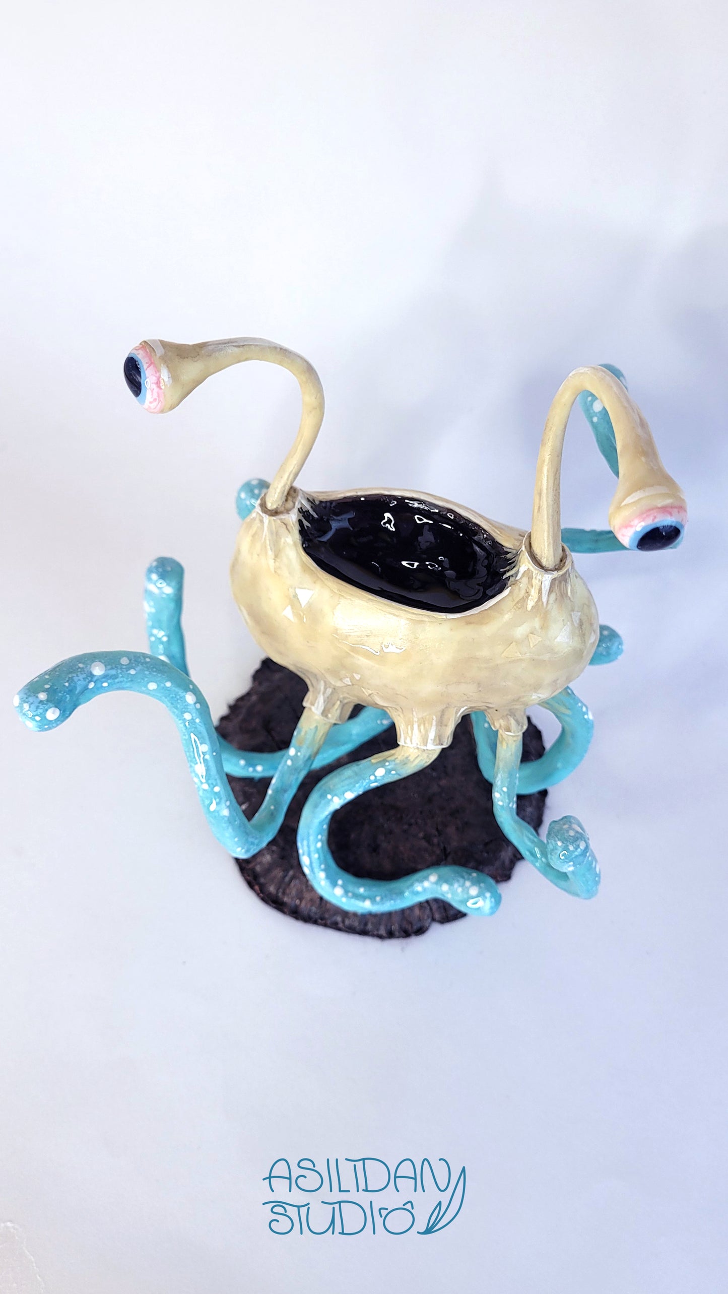 Figurine d'un Flumph de Donjons et Dragons, sorte de gros poulpe beige et turquoise