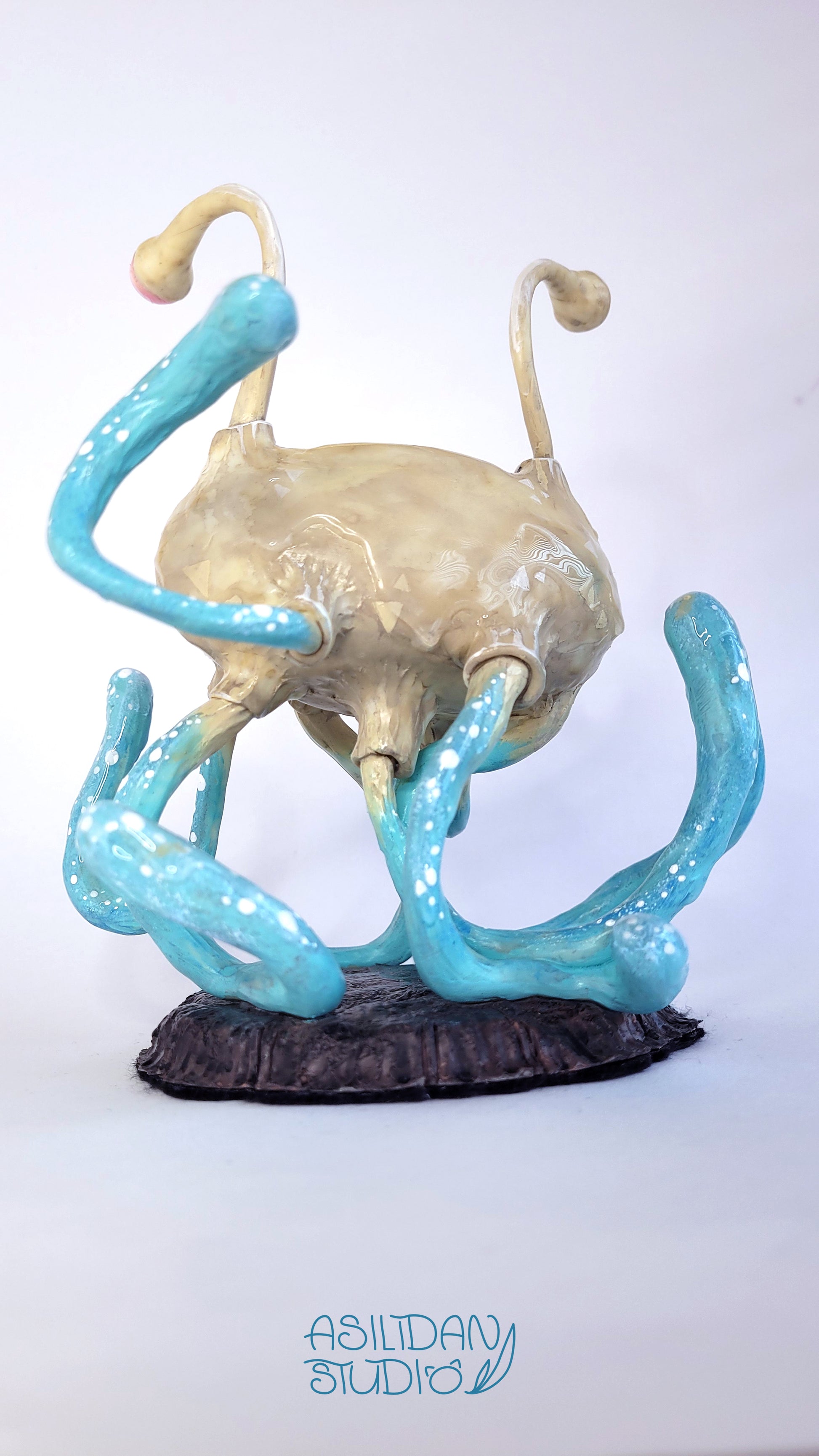 Figurine d'un Flumph de Donjons et Dragons, sorte de gros poulpe beige et turquoise