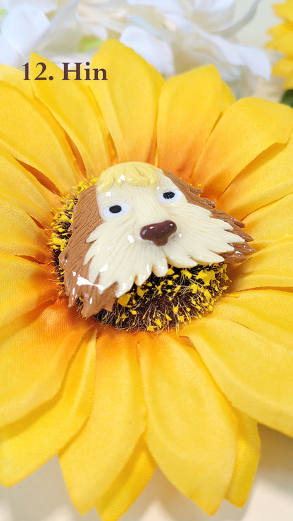 Pins en forme de la tête de Hin, chien du Château Ambulant, sur un tournesol