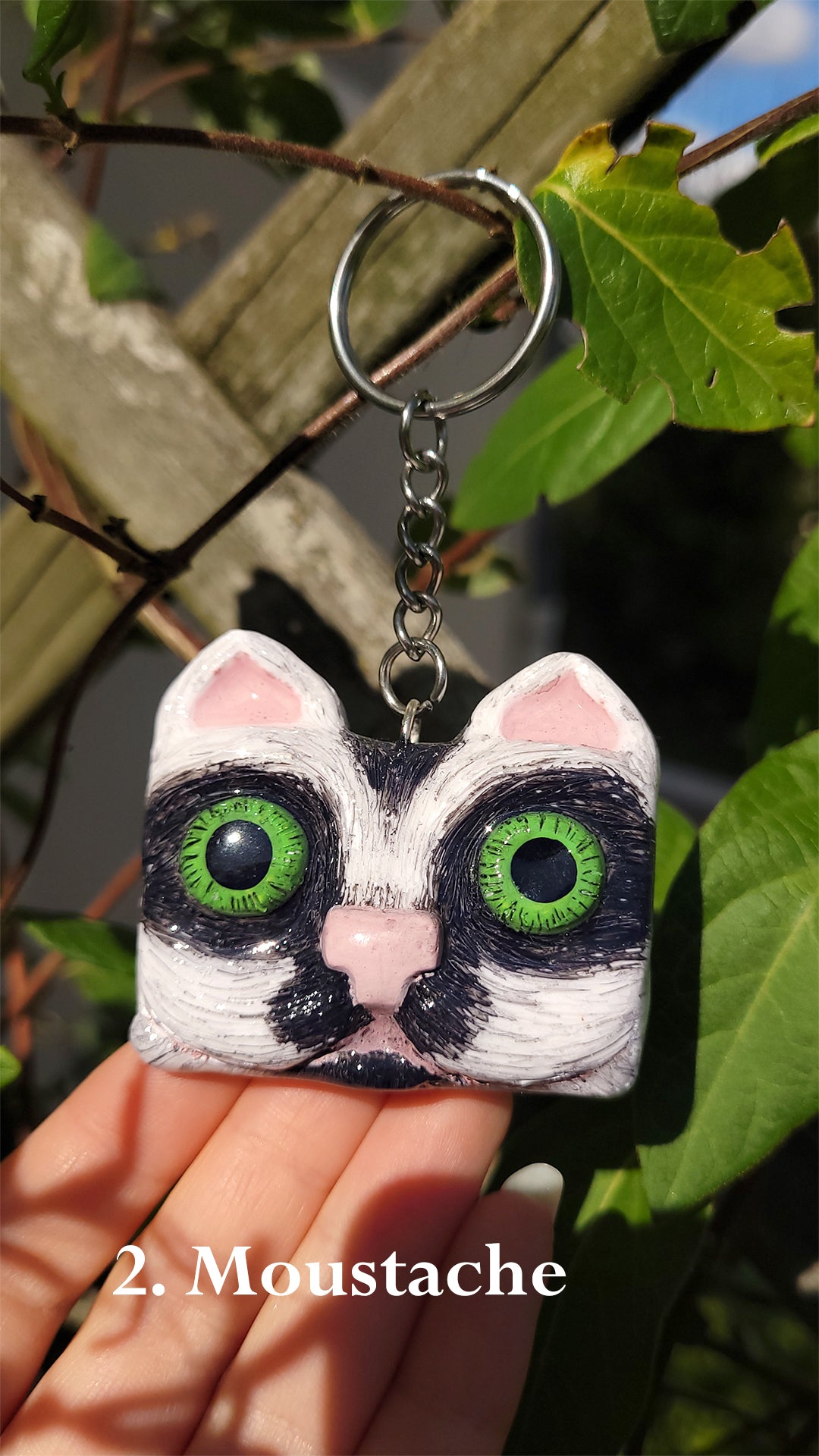  Porte clef en forme de tête de chat noir et blanc aux yeux verts