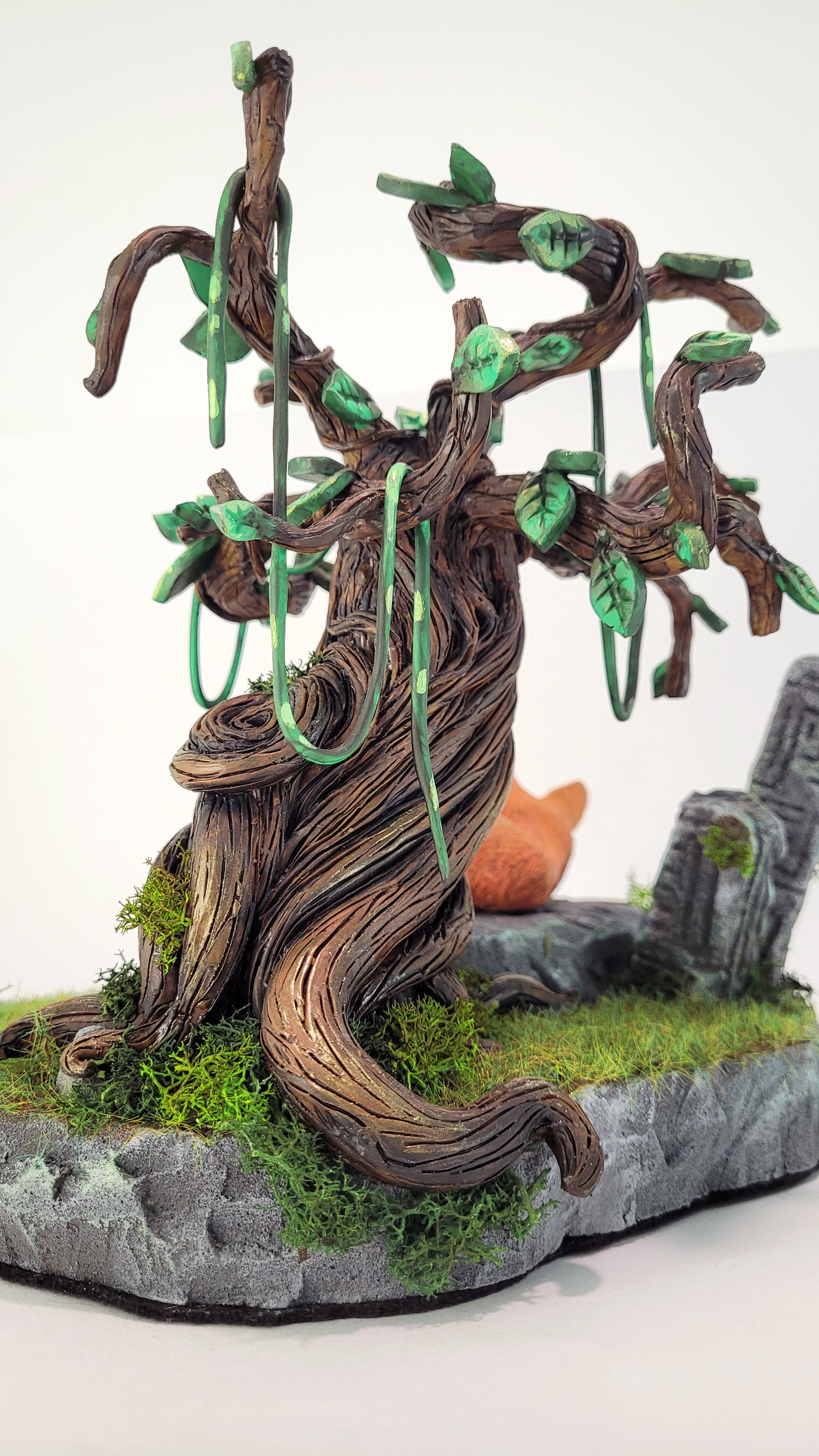 Diorama mettant en scène une figurine de renard dormant sur une pierre à l'ombre d'un arbre sinueux, au milieu de la nature et de ruines abandonnées