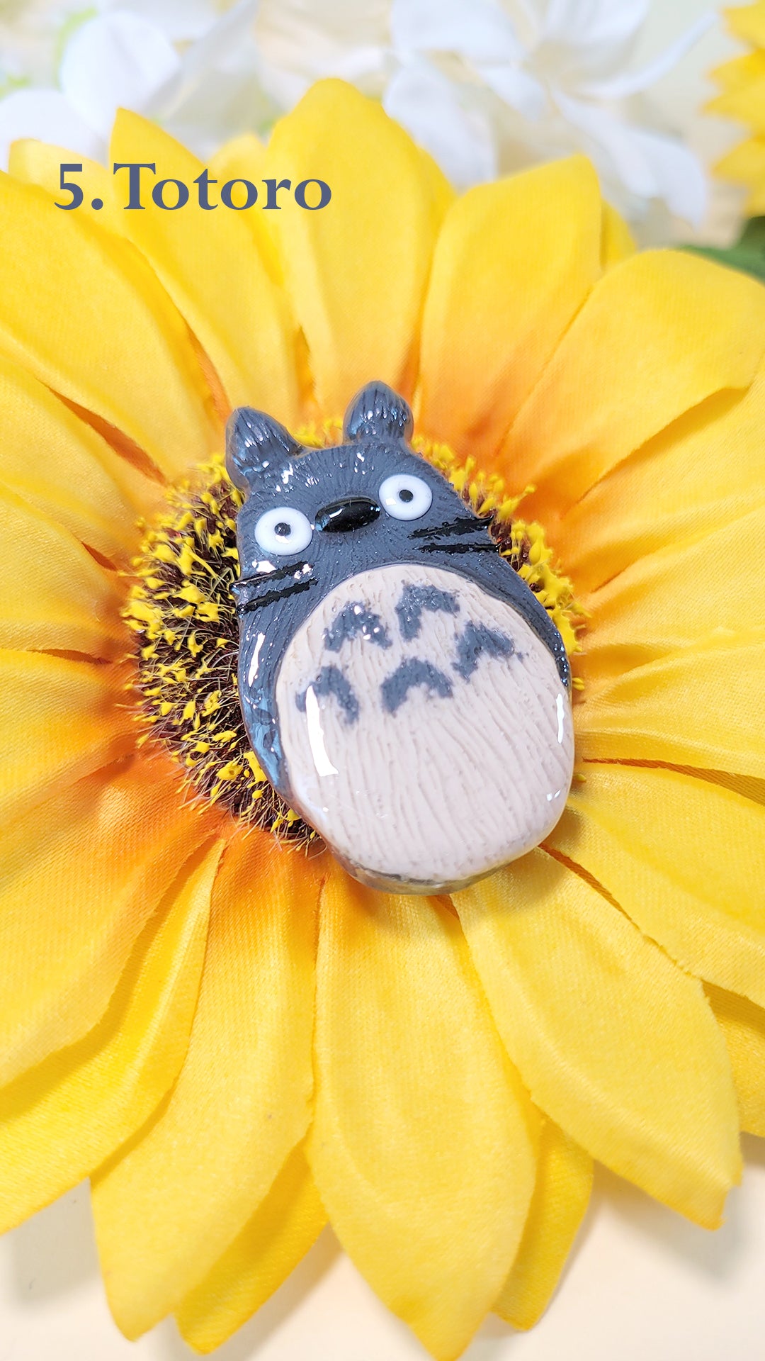 Pins en forme de Totoro, sur un tournesol