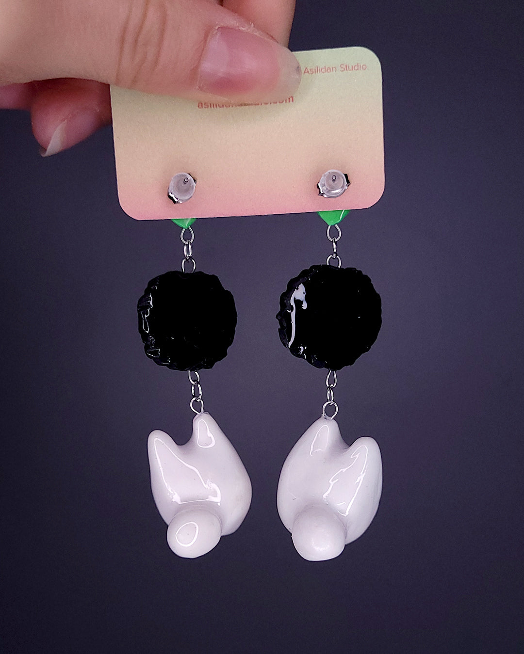 Paire de boucles d'oreille avec une feuille, une noiraude et un totoro blanc