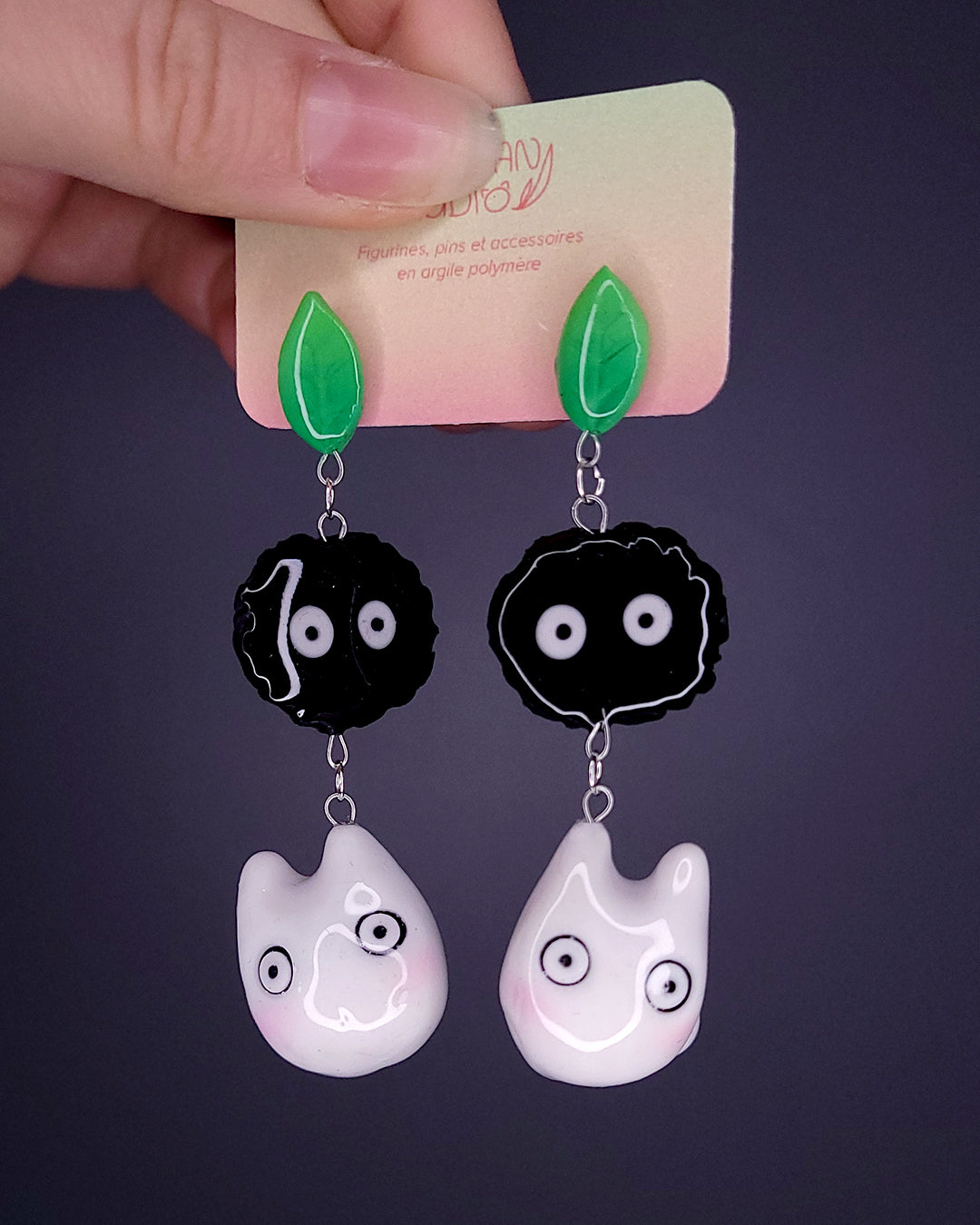 Paire de boucles d'oreille avec une feuille, une noiraude et un totoro blanc