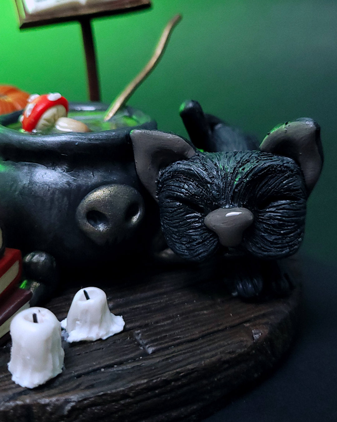 Diorama d'un atelier de potions avec un chaudron, des grimoires, un hibou, un chat noir