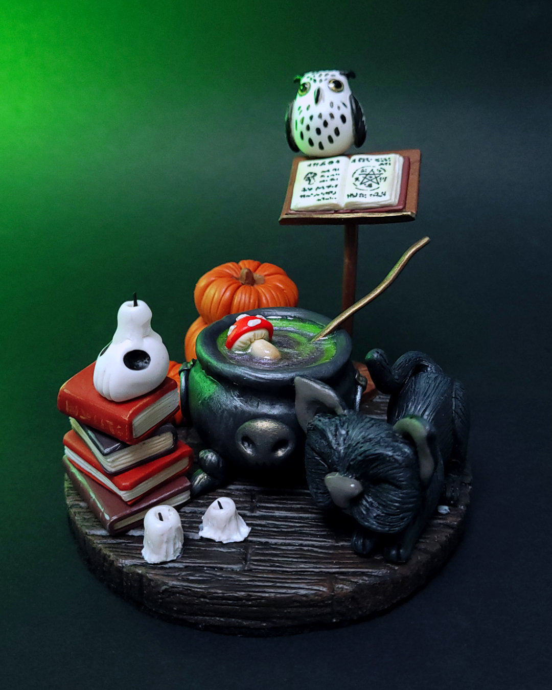 Diorama d'un atelier de potions avec un chaudron, des grimoires, un hibou, un chat noir