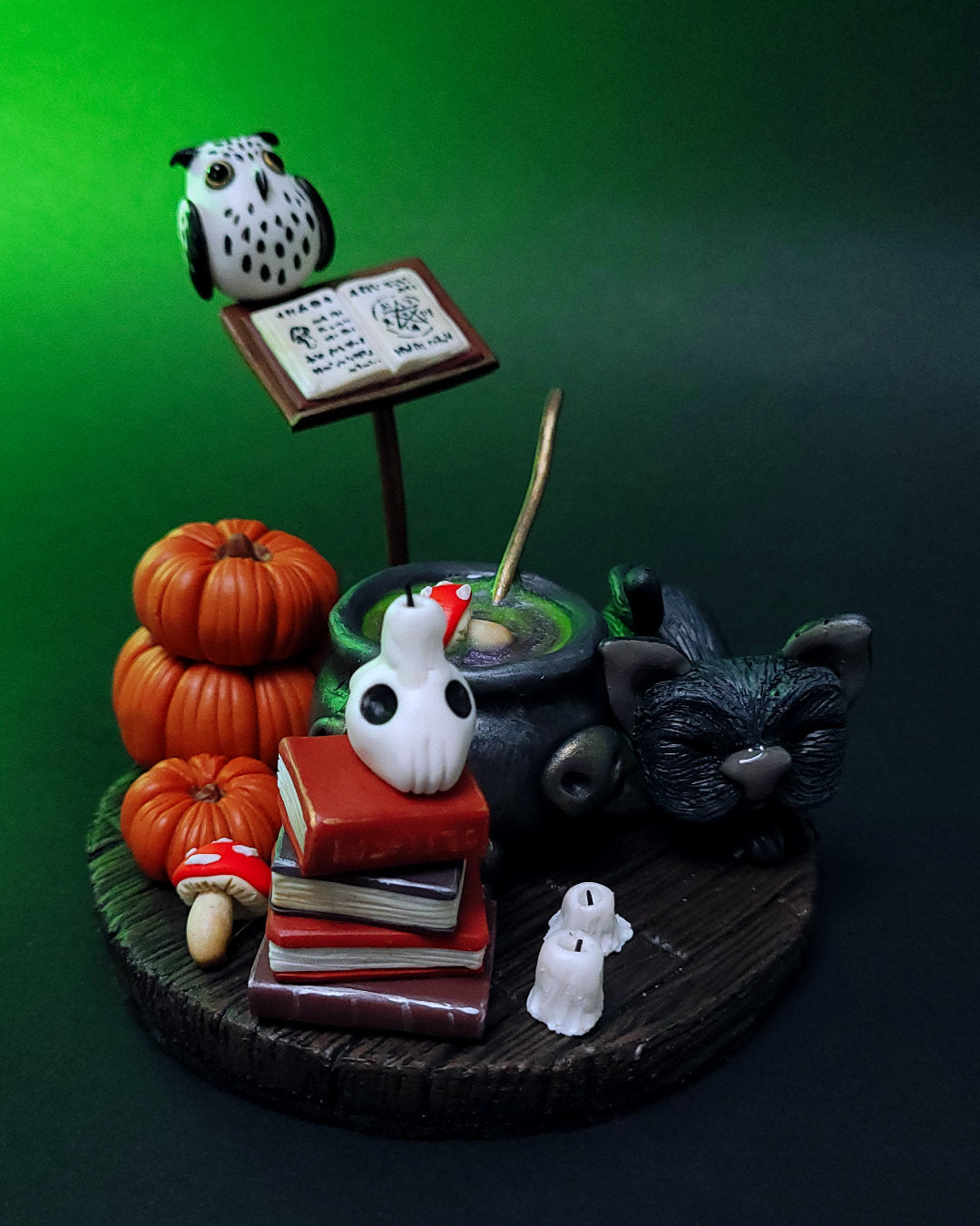 Diorama d'un atelier de potions avec un chaudron, des grimoires, un hibou, un chat noir