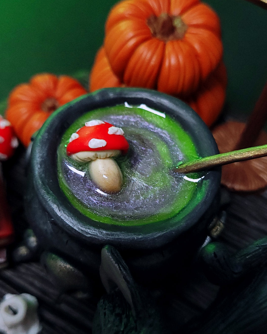 Diorama d'un atelier de potions avec un chaudron, des grimoires, un hibou, un chat noir